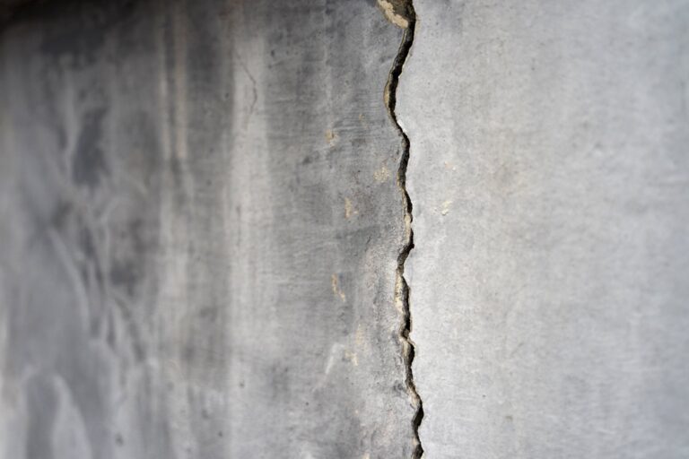 Vertical Crack in a Poured Concrete Foundation Wall, Indicating Potential Foundation Settlement or Structural Movement That May Require Professional Repair | Piermagic®