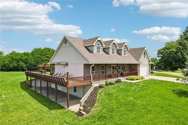 Residential Home in Harrisonville, Missouri Featuring a Wraparound Porch, Elevated Deck, Walkout Basement, and Spacious Yard on a Large Lot | Piermagic®